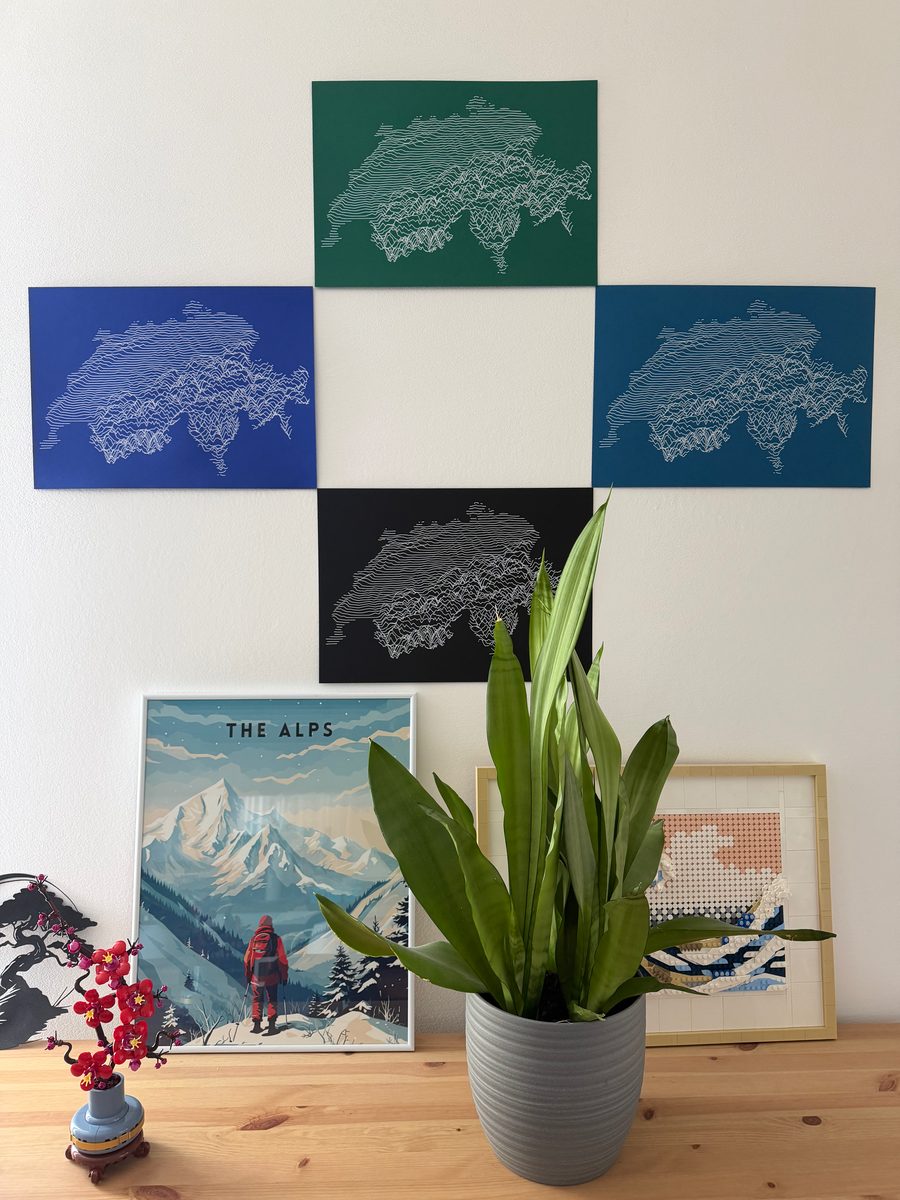 Swiss topography maps plotted on coloured paper, arranged on a living room wall